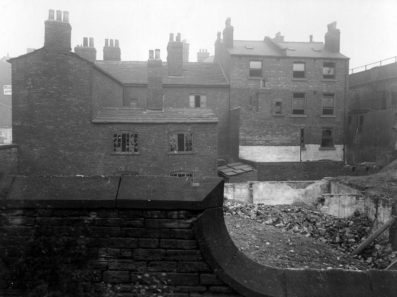 This view from July 1907 is taken from the burial ground of Leeds Parish Church. It shows the semi-derelict back views of several brick built, slate roofed houses, situated at the junction of York Street and Duke Street.