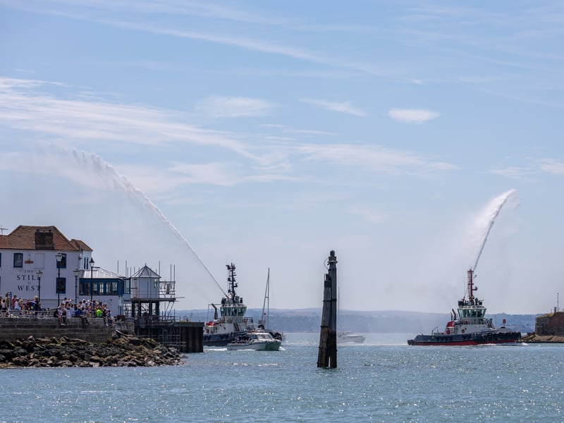 Tug boats display ahead of Clipper yachts returning to Portsmouth.