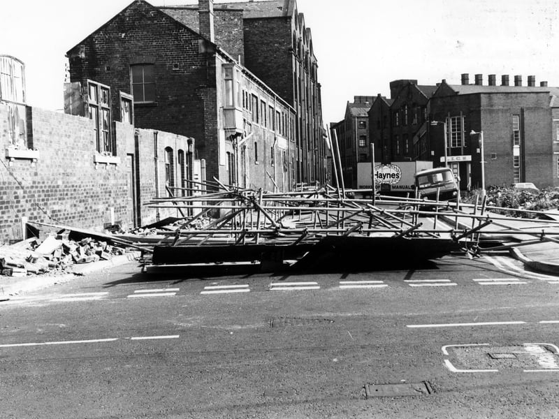 David Street looking from Manor Road in June 1986. On the left, demolition is taking place of nos.39-41 David Street, blocking off the road in the process. On the right is a cleared area where St. Francis' R.C. Church and St. Joseph's R.C. Secondary School once stood. Behind this is a department of the Leeds Industrial Co-operative Society.