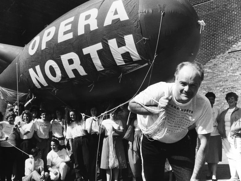 Opera North launched their own airship in May 1986 to publicise their visits to various towns around the country. Keith Cooper, head of publicity, hangs on to the guy ropes as the rest of the Opera North Company hold the balloon.