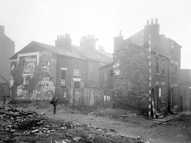Copenhagen Street was partly demolished to build New York Road, between North Street and Regent Street. This view shows a section of cleared land and property to be pulled down. A workman is on the roof, holding measuring rod. Pictured in November 1908.