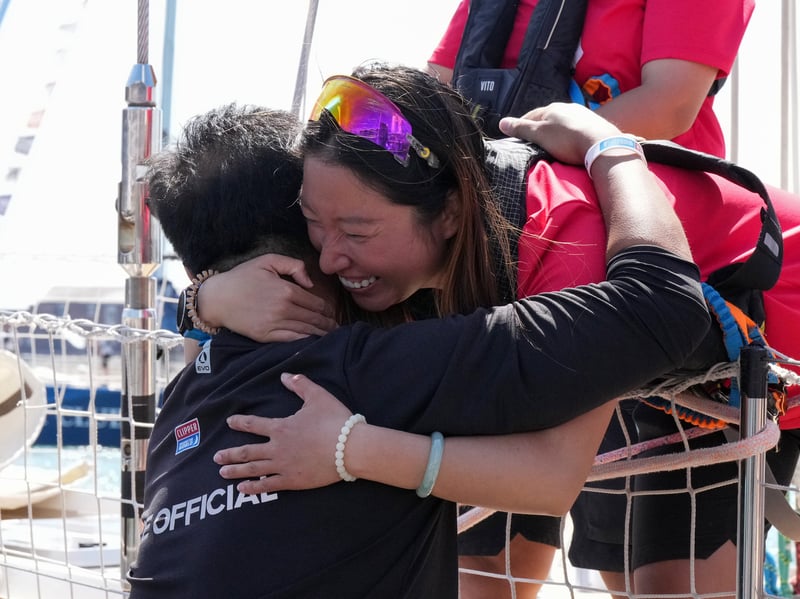 Crew member hugs their family after berthing on shore.
