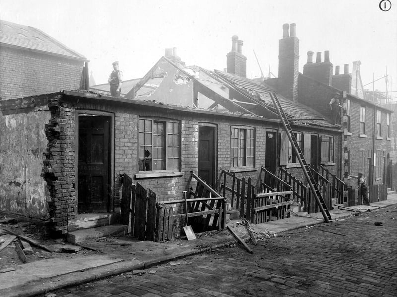 Demolition work in progress on Back Nile Street in September 1907, one storey houses are having roofs removed. Workmen and tools can be seen.