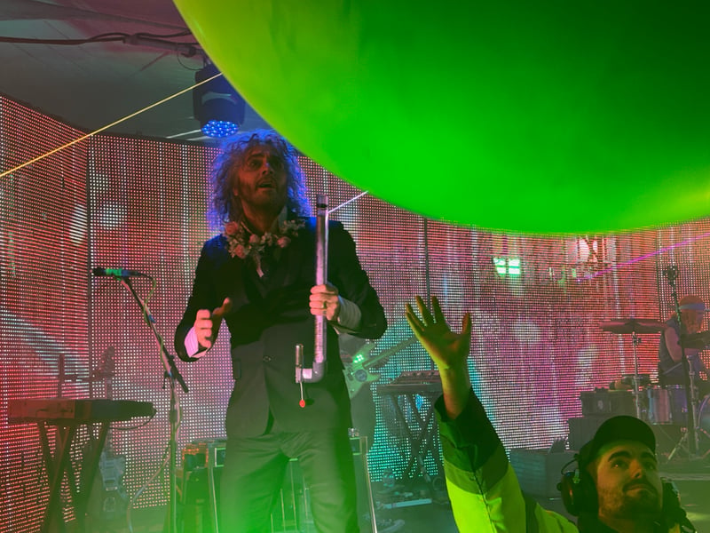 Wayne Coyne launches another balloon into the audience.