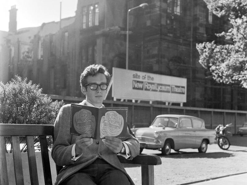 A visitor sits in Castle Terrace reading the Edinburgh Festival guide book in August 1966.