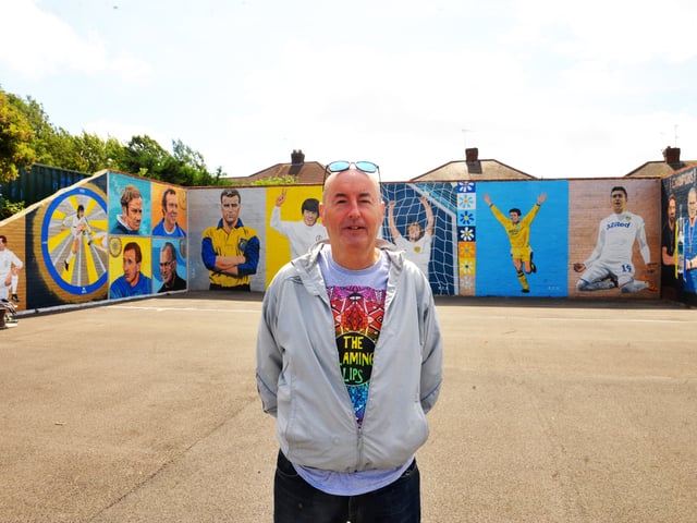 Artist Robert Endeacott by his mural for the Leeds United themed car wash at Elland Road 