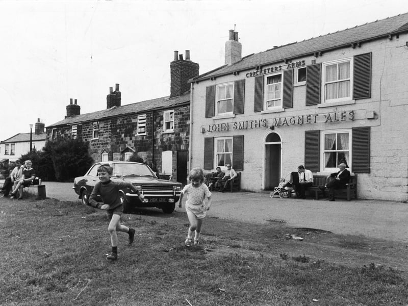 Youngsters play on the village green outside the Cricketers Arms pub in Seacroft, Leeds, in July 1972
