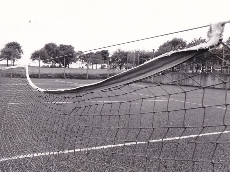 Legacy of neglect... a torn net hangs forlornly on the public tennis court on Woodhouse Moor in July 1978.