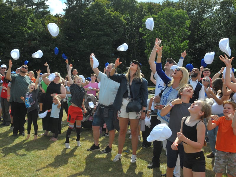 Visitors throw their flat caps in the air.