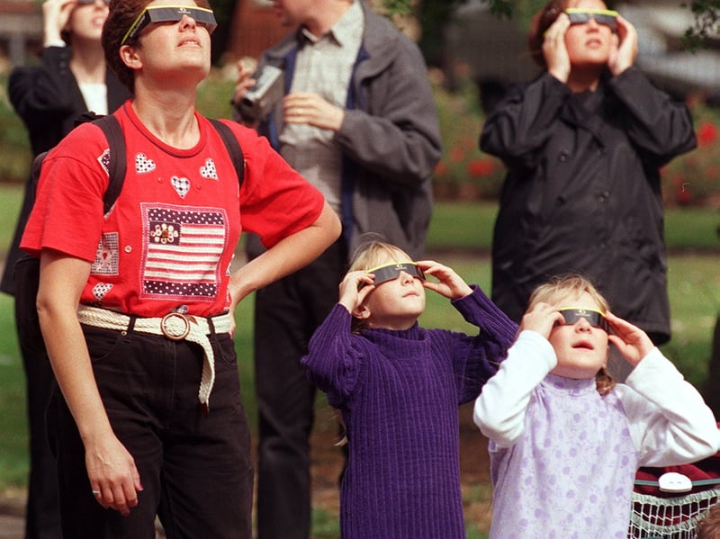 Office workers and members of the public down tools and gather in Park Square, Leeds, to watch the rare astronomical display unfold.