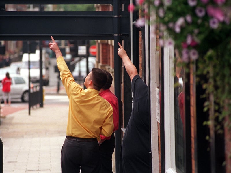 Shoppers and workers in Leeds city centre stop on the pavement and point toward the sky as the eclipse reaches its peak.