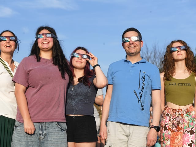 Pictured viewing the eclipse through special glasses.