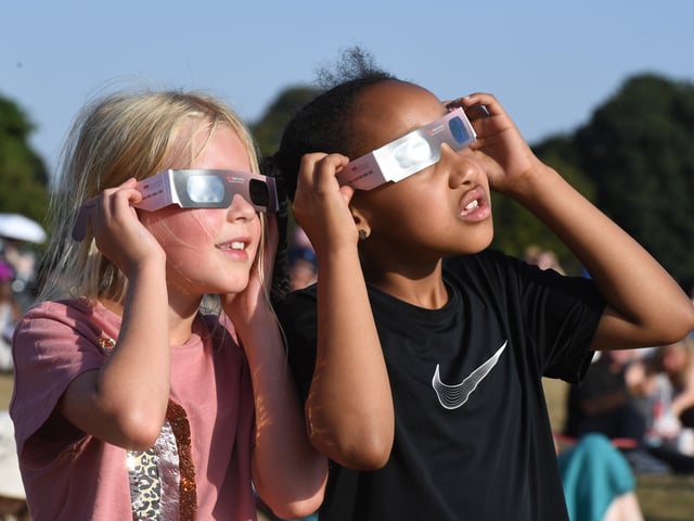 Pictured viewing the eclipse through special glasses