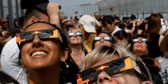 People wearing special glasses to look at solar eclipse