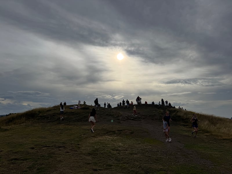 Eclipse-hunters arrive at the top of Blackford Hill.