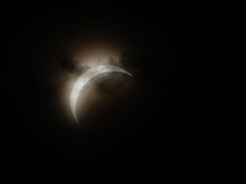 The sun is amost entirely eclipsed by the moon over Calton Hill.