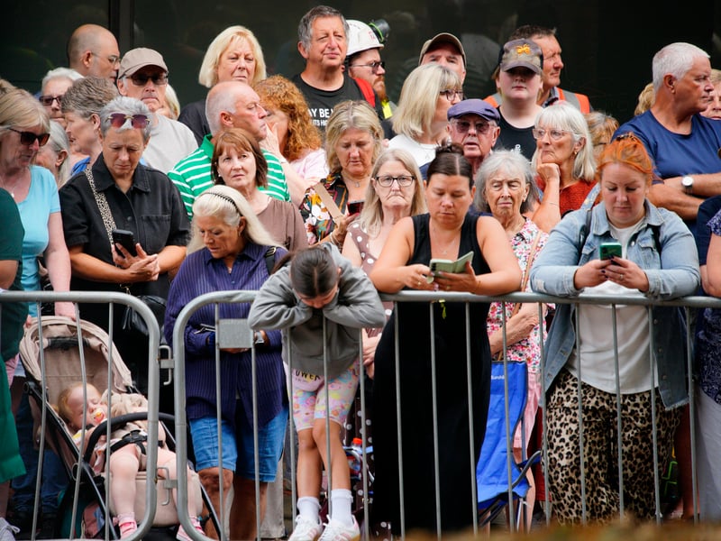 People wait behind barriers for the start of the funeral of Bonnie Tyler at Swansea Minster.