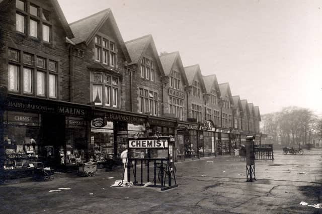 Parade of shops on Street Lane in December 1932. On the left no 59 are Harry Parsons, chemist and Raymond Malins, ironmonger, sharing a shop entrance. To the right, no 61 is Fred Burniston newsagent and Post office. Babies in their prams are outside the shops. An electric sign for the chemist is on the pavement.