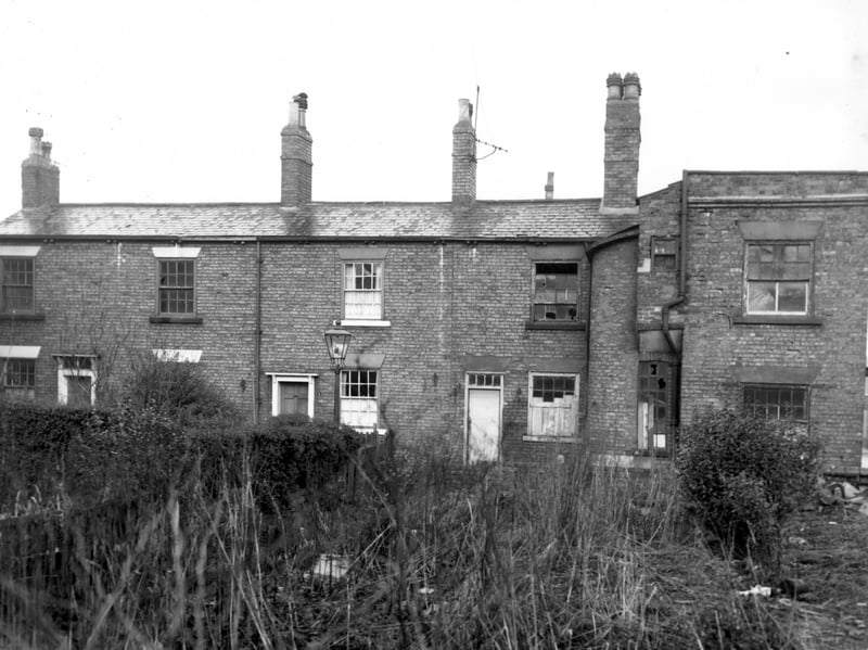 Number 1 Roger's Place is to the left of this view followed to the right by number 2. Both properties are partially obscured by a hedge. The side entrance to number 40 Chapel Lane is on the right, now derelict. Properties are due for demolition as part of the Armley slum clearance programme