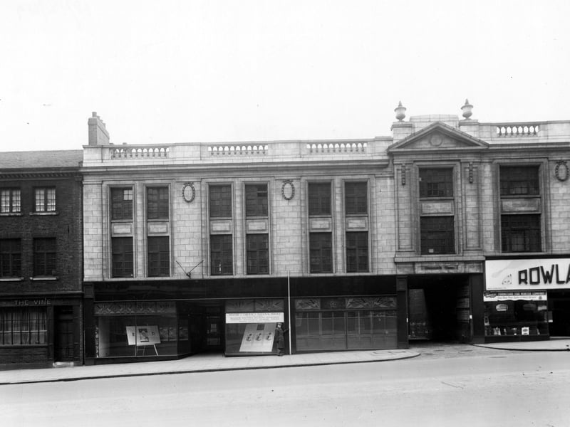 The south side of The Headrow showing number 11/13 The Vine public house, numbers 15 to 19 The Ministry of Labour and National Service Resettlement Advice Office. Next is Bromley's Yard, then number 21 Rowland Brothers furnishers.