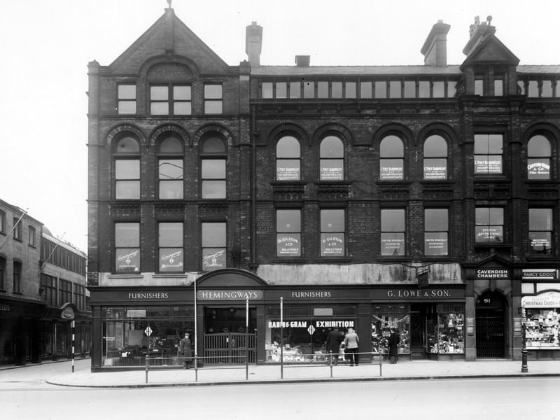 Numbers 85 to 91 on the South-West side of The Headrow. Number 85/87 Hemmingways Furnishers Ltd., number 89 G. Lowe and Son leather goods, 91 Cavendish chambers containing various accountants, solicitors and advertising agencies. To the left, the junction with King Charles Street can be seen. Pictured in December 1948.