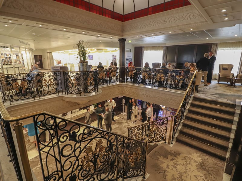 Pictured: Lobby area with passengers relaxing onboard ship.