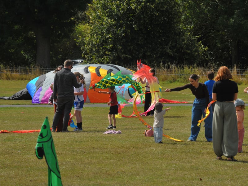 Youngsters with hand held kites as one of the bigger kites is grounded due to the lack of wind.