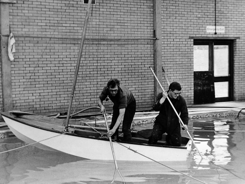 Newport swimming baths manager Errol Clark and attendant Christopher Winn take to a sailing dinghy to clean the baths in February 1972. The unusual method clearly came with its hazards – shortly before this picture was taken, Mr Clark had fallen in. Do you remember Newport swimming baths, or have any memories of swimming there as a child?