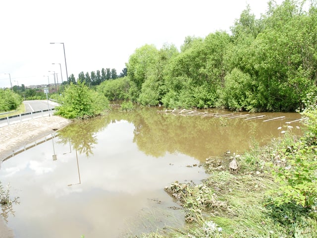 Doncaster Road, Denaby Main, is closed after heavy rain caused the river's banks to break.