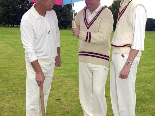 Doncaster Town 4th team captain John Lockwood (left) places the wickets in place-and hopes for a break in the rain- at Cantley Park, watched by  team-mates Tony Wilson (centre) and Tom Wallbank. The match was due to take place on Saturday (8/7/2000).
