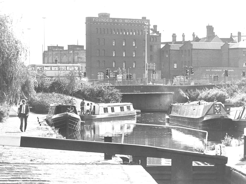 Canal boats pass beneath the tall Chubb Buildings on Fryer Street, Wolverhampton, in July 1989. The industrial buildings formed a striking part of the skyline, towering over the waterway and giving this scene a real sense of the town's working past. Do you remember seeing the Chubb Buildings from the canal?