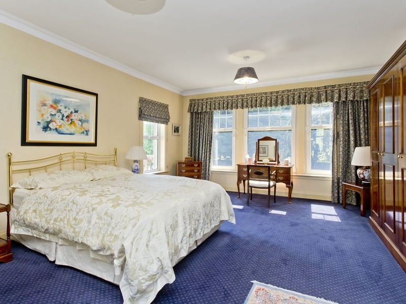 The first-floor landing leads to five well-proportioned bedrooms. This exceptionally spacious principal bedroom incorporates a broad bay window, and a character fireplace with a living flame fire.
