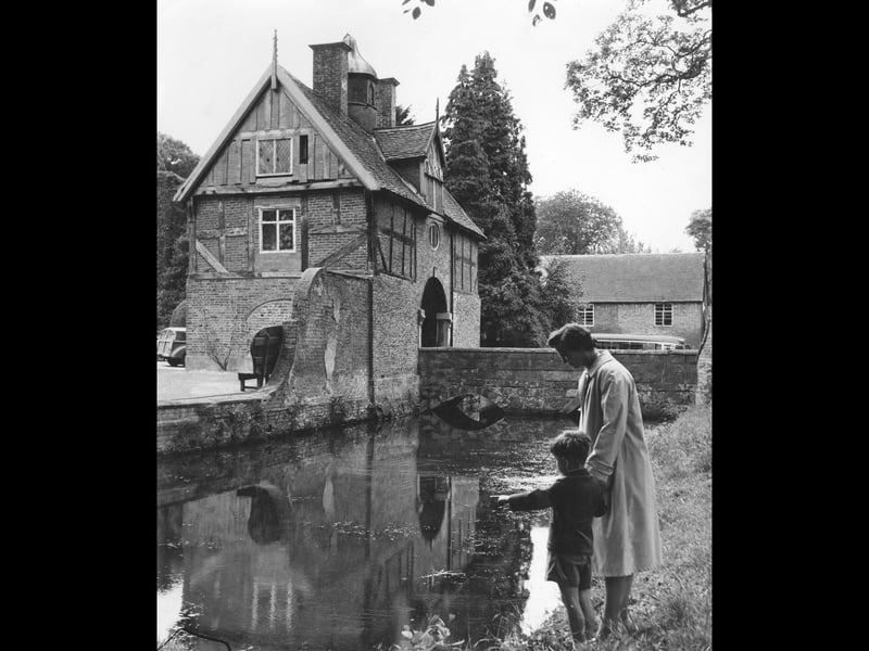 The moat and gatehouse at Orleton Hall, Wellington, are pictured on June 30, 1962, during the annual garden party for Shropshire people who were homebound or disabled. Mrs Barbara Noakes found a peaceful spot beside the Moat House, while her son Richard paused to admire the reflection in the water. A gentle summer scene that captures more than just the grand surroundings. Can you imagine spending an afternoon here in 1962? Do you remember the garden parties at Orleton Hall?