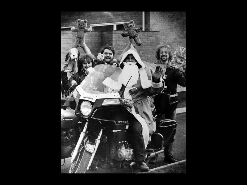 Santa Steve Bayley abandoned the traditional sleigh in favour of a motorcycle when he took gifts to children at Sandwell District General Hospital in December 1984. Steve and about 100 members of the Moonshiners Motorcycle Club from West Bromwich had spent several weeks gathering unwanted toys for 45 children on three wards at the hospital. Pictured helping are motorcyclists, from left, Carole Hurley, John Bunch, and Kella Jaundrill.
