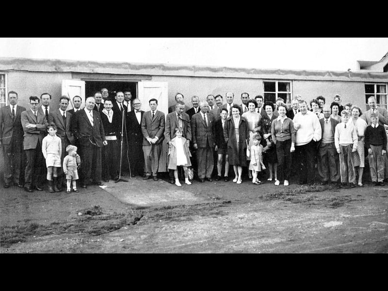 This 1962 photograph shows the opening of the locker rooms at Market Drayton Golf Club, facilities which remained in use until 1993, when the current clubhouse was built. The photograph was shared by Denis Roberts, who joined the club in 1971. He believes the child on the far left is Hughie Eardley, whose father Tony ran a large pet shop in Market Drayton, while the child towards the middle right may be John Cushing, now associated with Goldstone Hall. Denis also thinks the man in the white sweater is John’s father, Bill Cushing. The old locker rooms have since disappeared. Can you recognise anyone else in this picture, or remember the clubhouse as it looked in the 1960s?