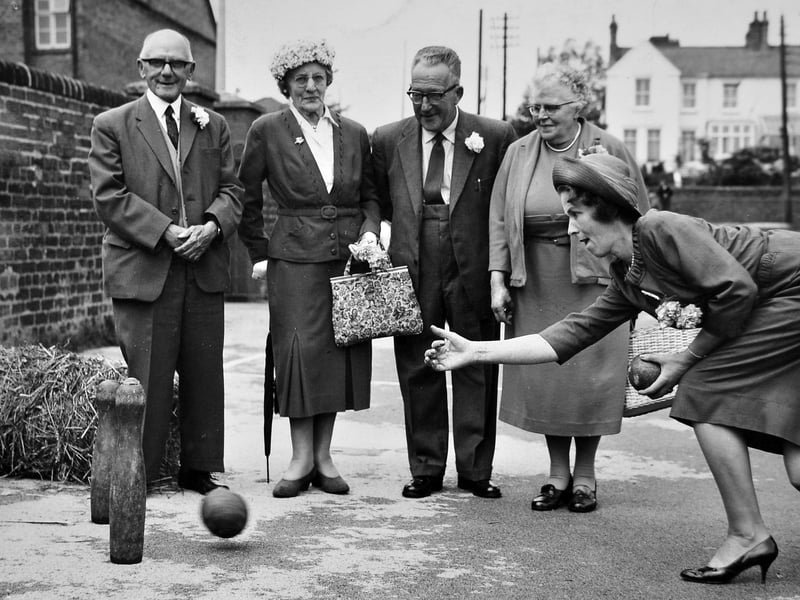 Eyes are glued to the skittles as the Countess of Cavan delivers a precise bowl during a lively gathering of the St Georges Good Neighbours Club circa 1963. Watching on with interest are Mr P Warrender, Mrs A F Dodd (wife of the former Priorslee vicar), Mr W V Fox, and fellow club supporters. Dressed in their finest Sunday best complete with buttonholes and elegant hats, the group showcases the fantastic community spirit and social activities enjoyed by local parish clubs across East Shropshire during the early 1960s. Do you remember attending the St Georges Good Neighbours Club events in the 1960s, or can you recognise any of the friendly faces lined up to watch the skittles match?