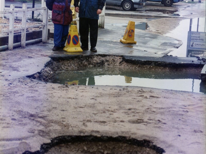 Two giant holes appear in the road after the water main burst in Hillsborough in December 1994