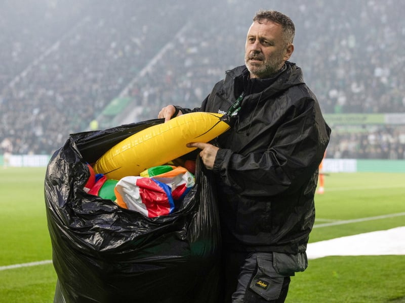 Ground staff clear beach balls from the pitch