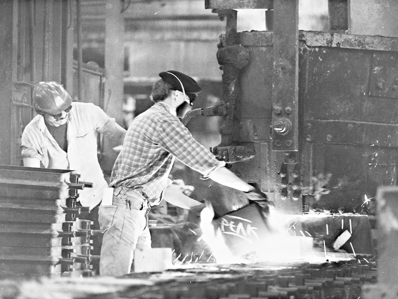 Workers are pictured pouring molten metal in a heavy industrial workshop in 1985, capturing the heat, skill and hard work of traditional foundry production. One worker carefully directs the glowing metal towards the moulds while a colleague monitors the operation nearby. The photograph reflects the efforts to modernise and revive traditional manufacturing during a difficult period for the region’s heavy industry. Can you identify this foundry or metalworks? Do you recognise the workshop or anyone pictured?