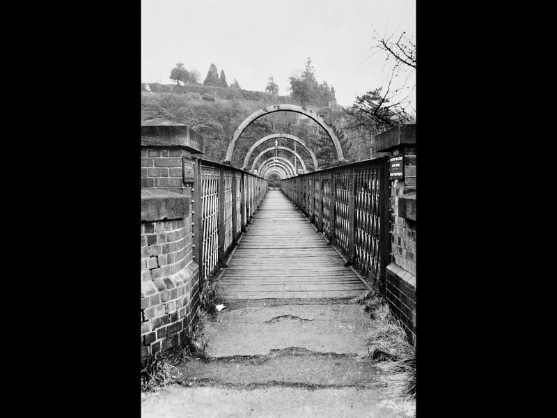 Framed by its distinctive arched ironwork, the long pedestrian footbridge at Bridgnorth railway station spans across the tracks in this striking photograph taken on 14 February 1967. Captured by photographer D G Salter of Oldbury, the atmospheric print records the historic structure during the early preservation era of the Severn Valley Railway. The original footbridge was later dismantled and replaced, making this image a valuable record of the station's changing skyline over the decades. Do you remember walking across this original footbridge at Bridgnorth station before it was replaced?