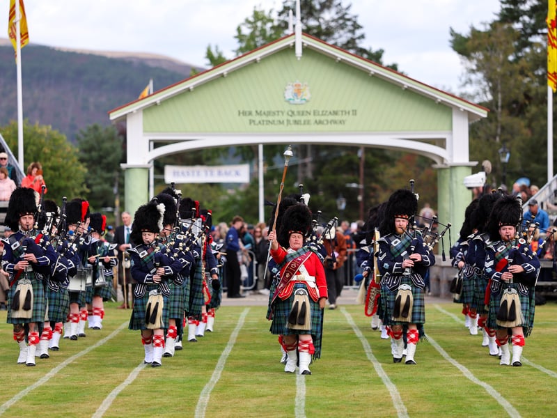 A pipe band passes under the Platinum Jubilee arch at The Princess Royal and Duke of Fife Memorial Park 