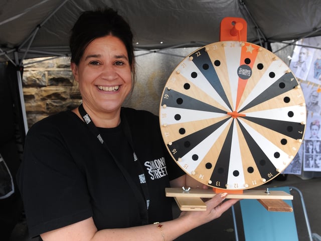 Natalie Clark CEO Sim on the Streets with the wheel of fortune as she raises money for the homeless.