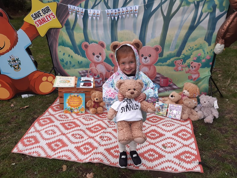 This youngster was surrounded by an array of teddy bears.