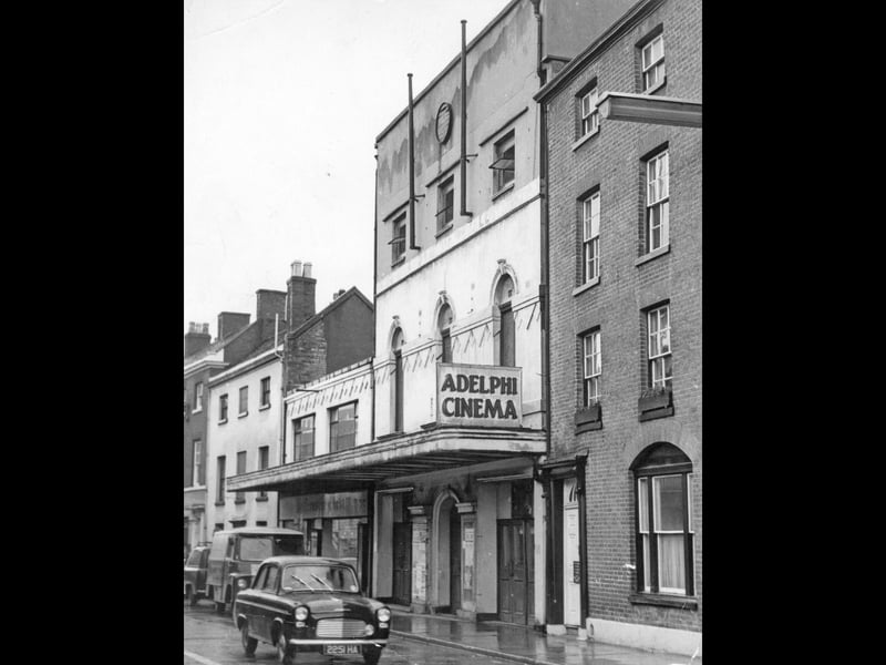 A classic Ford Anglia drives past the distinctive canopy of the Adelphi Cinema on George Street in Lichfield during a damp January day in 1962. Originally built as the Palladium in the 1920s before being renamed, the popular venue served as a favourite entertainment hub for local filmgoers, screening everything from Hollywood blockbusters to weekly newsreels. The building later found a second life as a bingo hall, but this nostalgic snapshot captures it in its picture-house heyday, complete with movie posters and classic early '60s cars parked along the street. Do you remember queueing up outside the Adelphi to catch a film in the 1960s?
