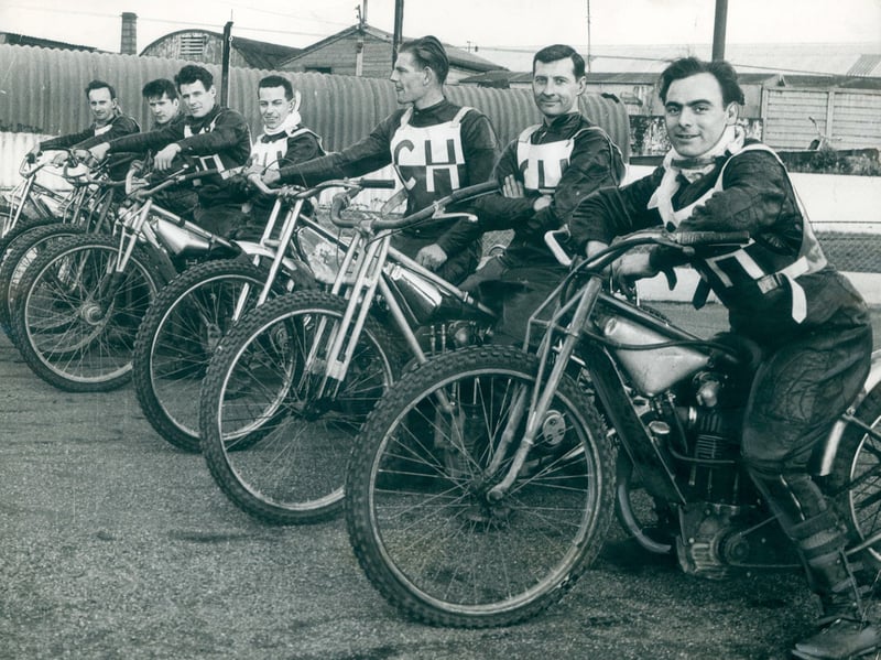 Riders line up on their classic, brakeless bikes ahead of the first race of the new speedway season in April 1962. Dressed in their protective leathers, bibs, and neck guards, the squad poses trackside before hitting the shale for an action-packed night of high-speed racing. Monmore Green Stadium was renowned for its electric atmosphere, drawing passionate crowds of motorcycling fans who gathered every week to cheer on their local heroes under the stadium floodlights. Do you remember hearing the roar of the engines from the terraces at Monmore Green back in the 1960s?