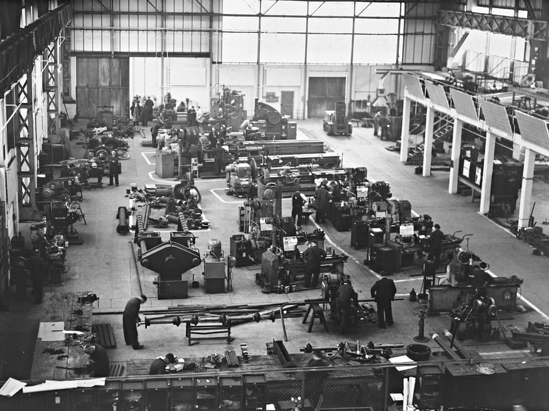 A high-angle view captures the hive of activity inside the Central Engineering Shop at Bilston Steelworks in 1962. Formerly part of Stewarts & Lloyds, the site relied heavily on these skilled tradesmen to keep the vast iron and steel plant running. Blast furnace and crane fitters worked along the elevated section on the right, while blacksmiths occupied the far right corner, surrounded by heavy lathes and machinery. Among the workforce pictured hard at work are thought to be local men Benny Barwell, Sammy Briscow, and Alan Braden. Did you or any of your family work at the famous Bilston Steelworks back in the 1960s?
