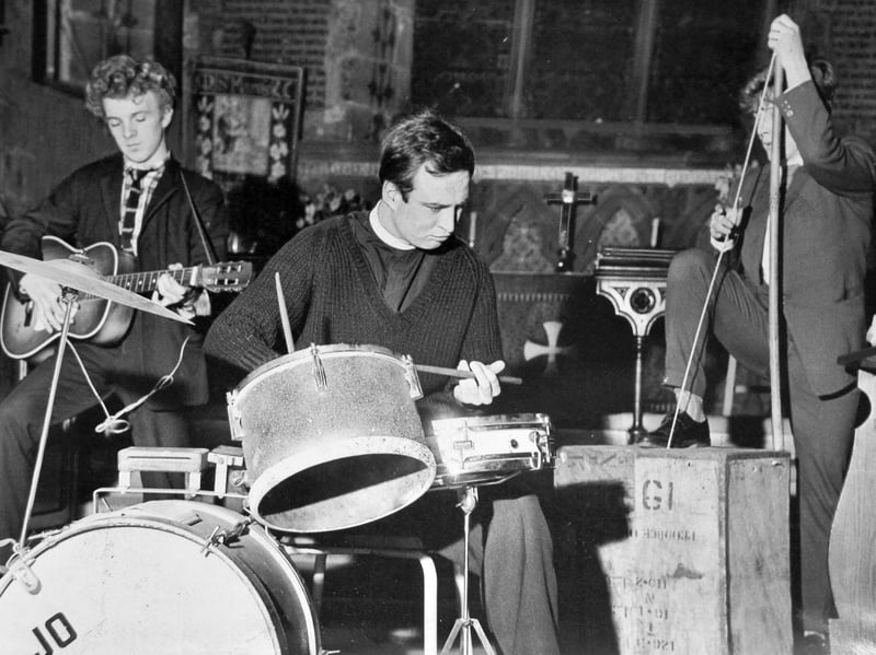 Local curate the Rev Jo Martin gets "with it" on the drum kit during a lively youth service at Bushbury Parish Church in April 1962. Flanked by guitars and a tea-chest bass strumming along to the rhythm, the modern gospel session brought a fresh, contemporary sound to traditional hymn singing. Organised by the vicar, the Rev C A Chamberlain, to engage younger parishioners, the special post-service session proved a resounding success, drawing around 160 enthusiastic young people into the pews. Do you remember attending youth services or hearing modern music brought into local Black Country churches in the 1960s?