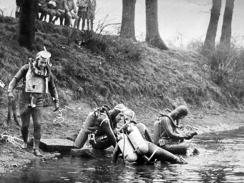 Under the watchful eyes of curious young spectators lined up along the bank, divers from the Willenhall branch of the British Sub Aqua Club emerge from the chilly waters of Parkes Hall Pool in Woodsetton on February 3, 1962. The experienced sub-aqua team volunteered to conduct a free underwater investigation for Coseley Urban District Council, which had grown concerned over a sharp decline in fishing permit receipts. However, after exploring the depths, the frogmen surfaced with surprising news for local council officials and waiting anglers - they hadn't spotted a single fish. Do you remember fishing at Parkes Hall Pool in Woodsetton or watching the local frogmen carry out their underwater search in 1962?