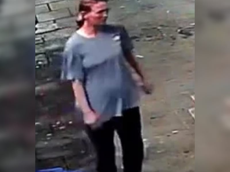 Female with brown hair tied back, grey/blue long t-shirt, black joggers with a stripe down the leg.