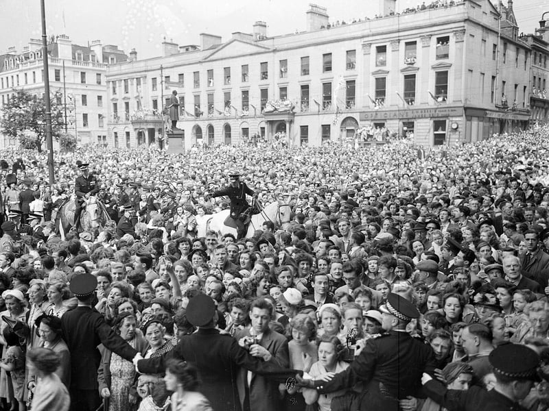 A crowd in George Square greets Queen Elizabeth II during her 1953 coronation visit.